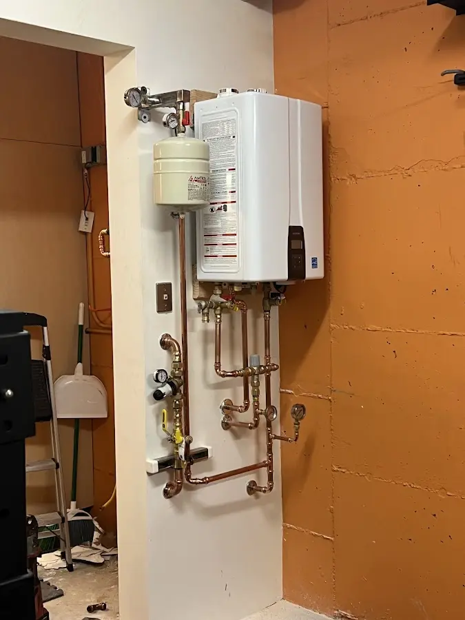 Plumbing technician inspecting water heater connections in Maryland Heights